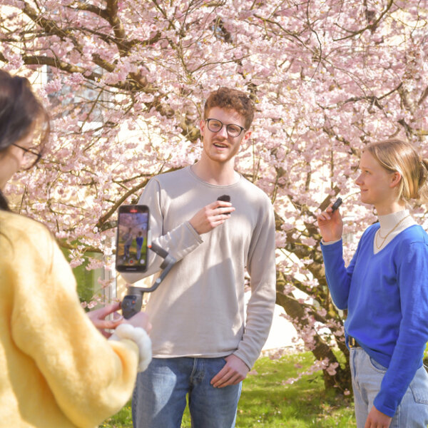 Studierende nehmen ein Video mit einem Gimbal und Funkmikrofonen auf.